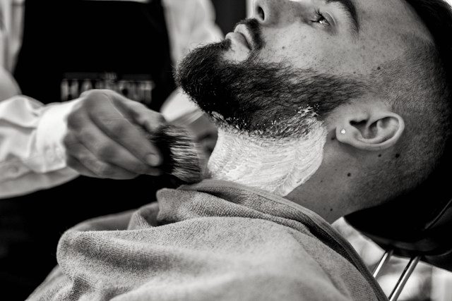 A lathered hot towel shave in progress.