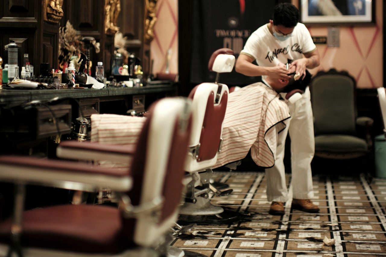 The shop floor at Kenny's — vintage chairs lined up beneath warm lamps.